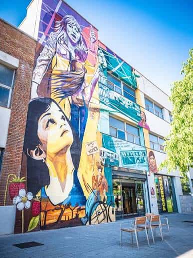 Fachada lateral del espacio municipal con mural artístico colorido
