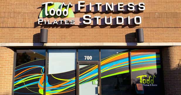 Fachada exterior del estudio Todd Pilates & Barre con letrero y ventanales decorados