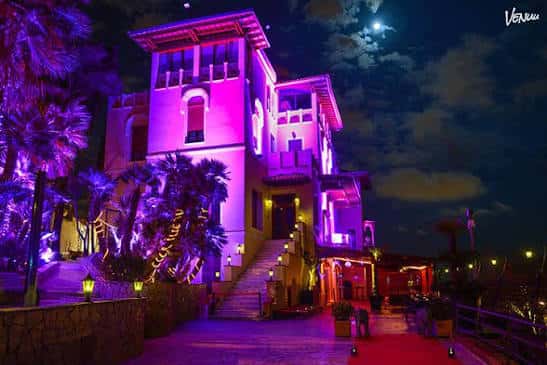 Fachada exterior del edificio Atlantic Club Barcelona iluminado con luces de colores por la noche