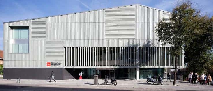 Fachada frontal de la biblioteca mostrando entrada principal y detalles arquitectónicos contemporáneos