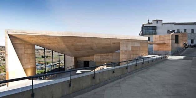 Vista exterior del Palacio de Congresos El Greco con su característica cubierta inclinada y fachada de piedra
