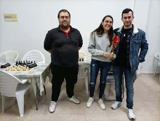 Premiación informal en el club de ajedrez con trofeo y tableros sobre mesas