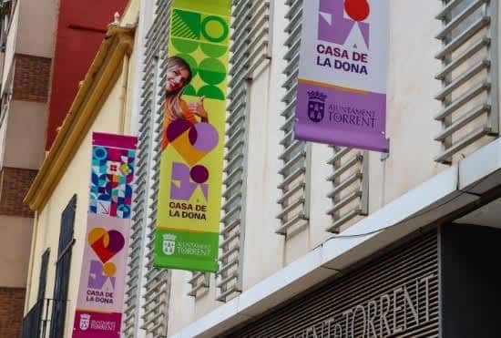 Fachada exterior de la Casa de la Dona Torrent con banderines institucionales