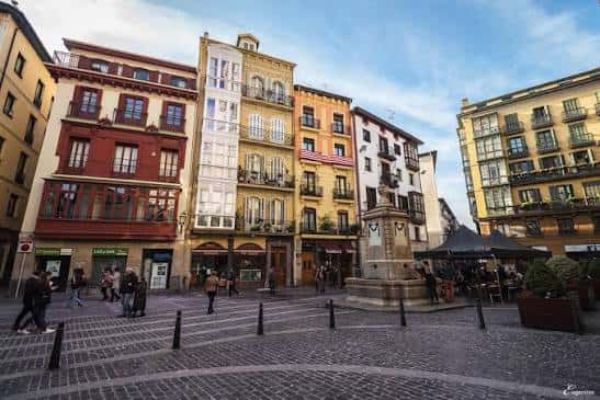 Plaza de Santiago con edificios históricos y fuente central bajo cielo azul