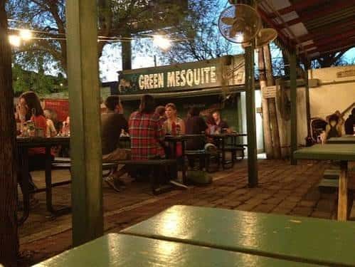 Vista exterior del restaurante Green Mesquite con clientes sentados en mesas al aire libre
