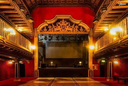 Escenario principal del teatro con decoración clásica y cortinas rojas