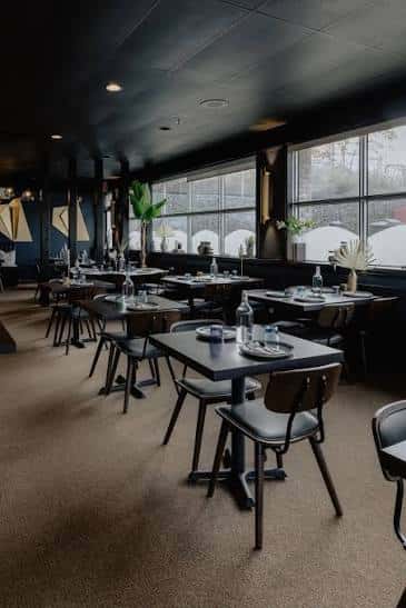 Sala de comedor preparada para eventos con mesas dispuestas y decoración moderna