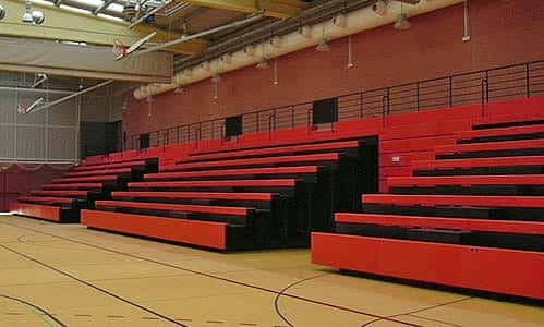 Vista del interior del pabellón con gradas rojas y pista de baloncesto