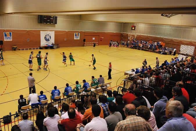 Partido de baloncesto en el Polideportivo Los Rosales con espectadores