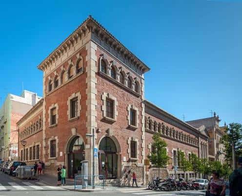 Fachada exterior de la Biblioteca Pública de Tarragona con arquitectura de ladrillo y arcos