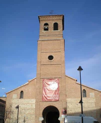 Fachada principal de la Parroquia San Sebastián Mártir con torre de ladrillo y campanas