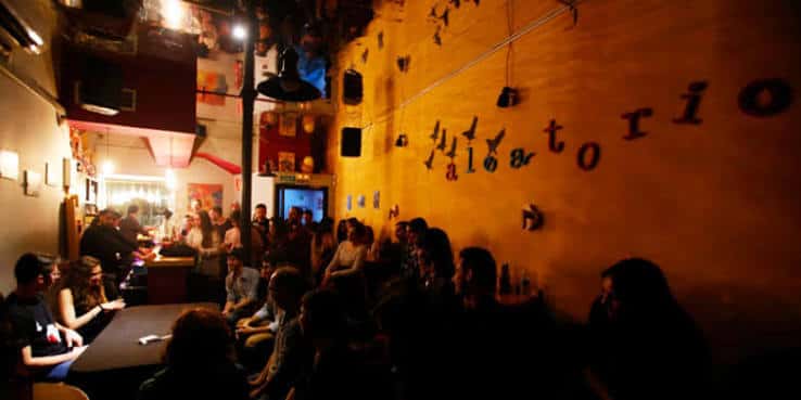 Interior del Aleatorio Bar con decoración artística y público disfrutando de un evento en vivo