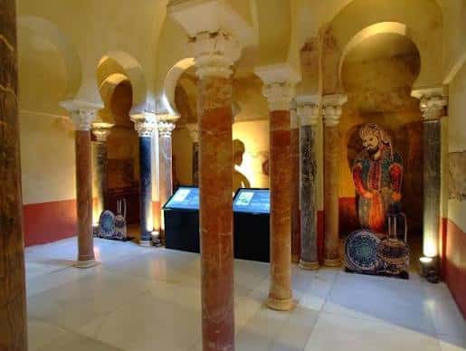 Sala de exposición con columnas ornamentales y vitrinas iluminadas