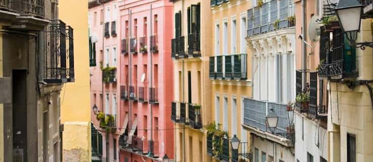 Fachadas coloridas y balcones tradicionales en una calle estrecha del barrio