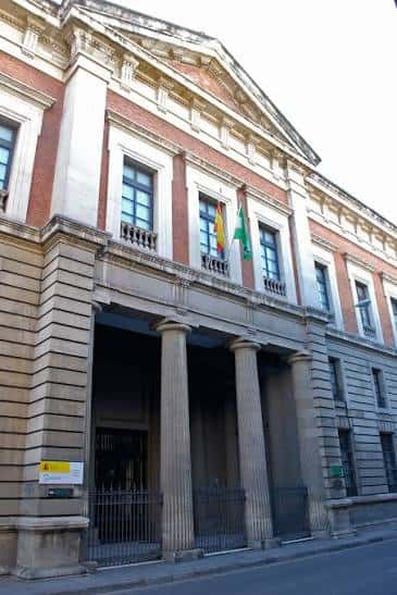 Fachada principal del Archivo Histórico Provincial de Sevilla con columnas y banderas