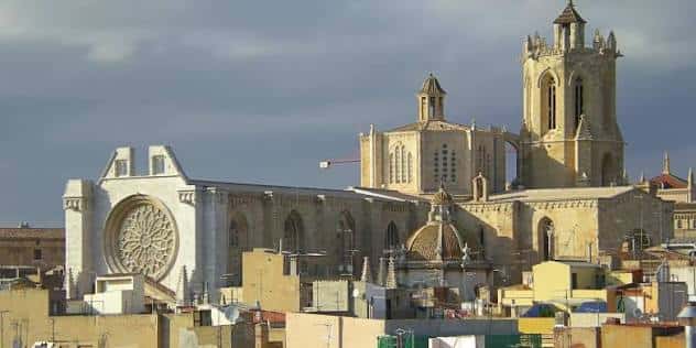 Vista panorámica de la Catedral de Tarragona con su fachada gótica y torre campanario bajo cielo nublado
