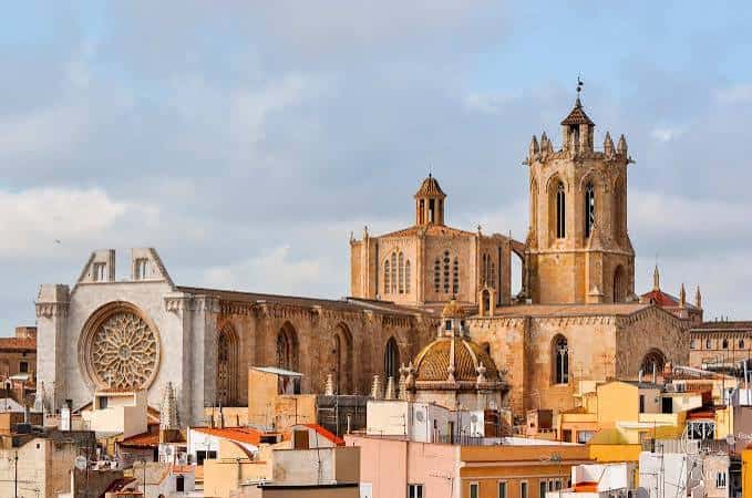 Panorama diurno de la Catedral Metropolitana de Santa Tecla en Tarragona, destacando su arquitectura medieval entre tejados urbanos