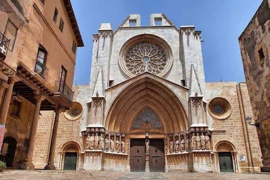 Fachada principal de la catedral con rosetón gótico, portadas esculpidas y plaza adoquinada frente a ella