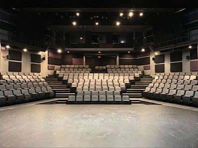 Sala de eventos con disposición de butacas en abanico y escenario amplio