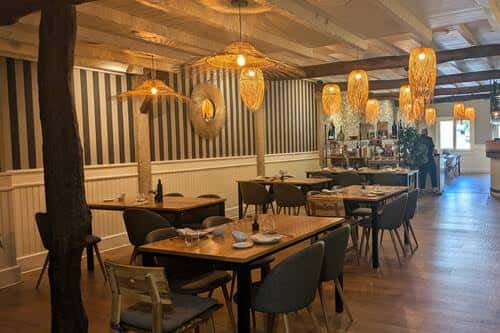 Interior del comedor principal con decoración rústica y lámparas de mimbre