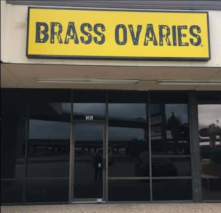 Fachada exterior del local Brass Ovaries con su distintivo letrero amarillo