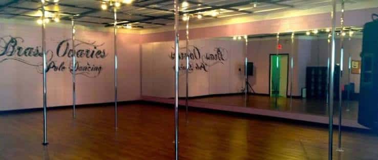 Interior de la sala de baile con múltiples barras verticales y espejos en las paredes