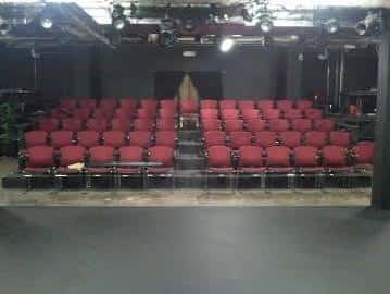 Interior del auditorio con butacas rojas dispuestas en filas frente al escenario