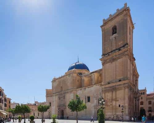 Vista exterior de la Basílica de Santa María con su característica cúpula azul y torre bajo un cielo despejado