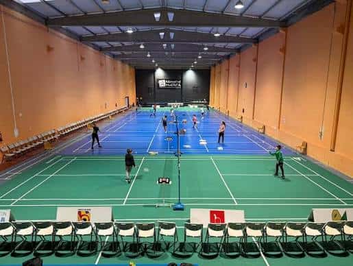 Vista interior de las pistas de bádminton del Club Bábadminton Huesca con jugadores en actividad