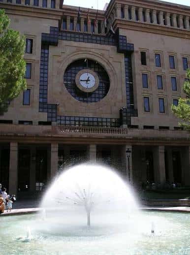 Plaza con fuente central y edificio monumental con reloj