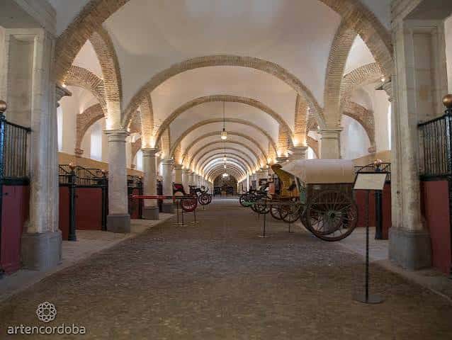 Interior del pasillo abovedado con carruajes históricos expuestos