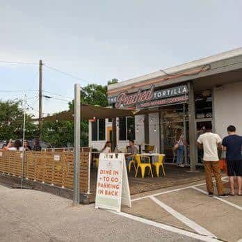 Vista exterior del restaurante The Peached Tortilla con terraza y clientes