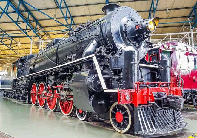 Locomotora de vapor negra con ruedas rojas en primer plano