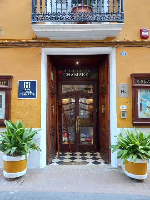 Entrada principal del Art Boutique Hotel Chamarel con fachada amarilla y puertas de madera