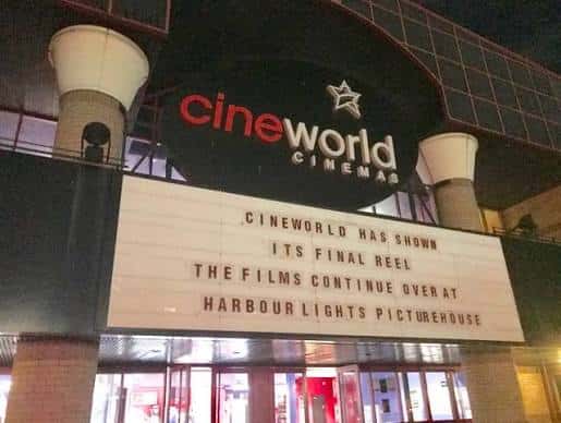 Vista nocturna de la entrada del cine mostrando el cartel de cierre
