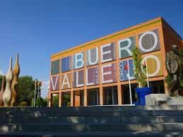 Entrada del centro cultural con esculturas modernas y banderas