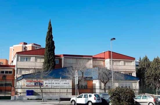Vista exterior del CEIP Daniel Martín con fachada de ladrillo y techo rojo bajo cielo despejado