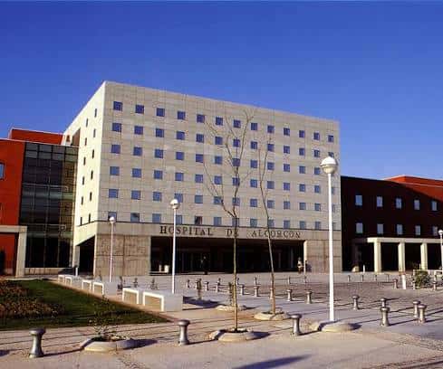 Vista frontal del Hospital de Alcorcón con fachada de piedra y cielo azul
