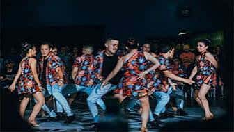 Grupo de bailarines actuando en un escenario durante una función