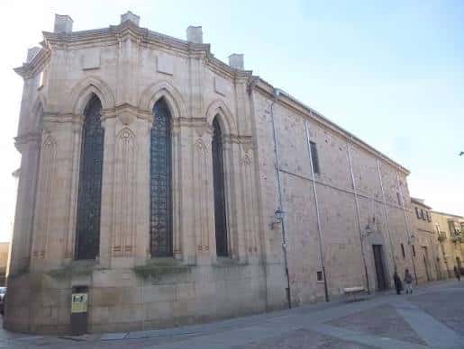 Fachada lateral del Convento del Corpus Christi con ventanas góticas y mampostería de piedra