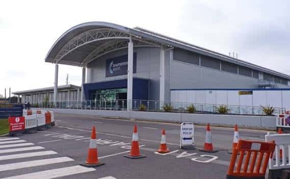 Vista exterior del edificio del aeropuerto con señalización de tráfico en primer plano