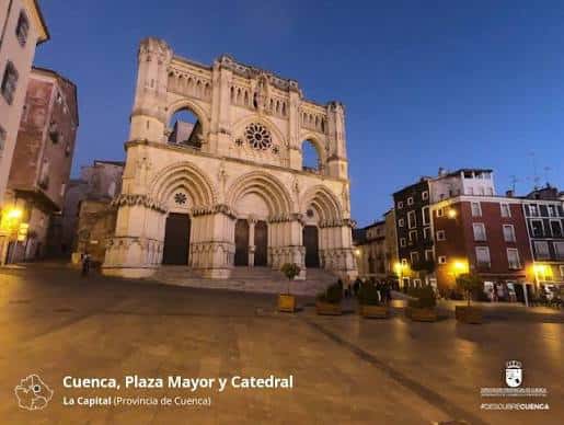 Fachada iluminada de la Catedral de Cuenca en la Plaza Mayor al atardecer