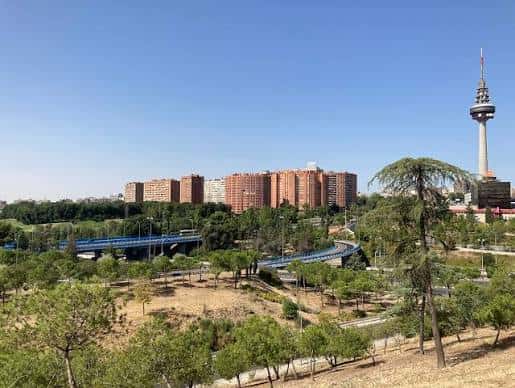 Panorámica del parque con la torre de Madrid al fondo y edificios residenciales