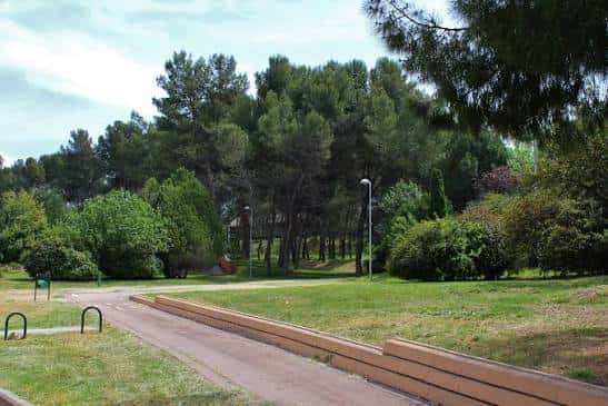 Sendero peatonal con bancos integrados y vegetación mediterránea