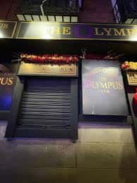 Fachada exterior de The Olympus Club en Madrid con letrero iluminado