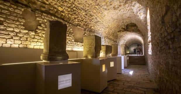 Interior museístico del Pretorio con columnas romanas expuestas bajo bóvedas de piedra