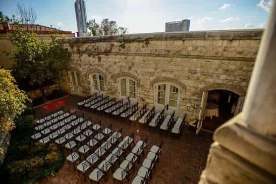Cortijo interior preparado para una ceremonia con sillas dispuestas bajo el cielo abierto