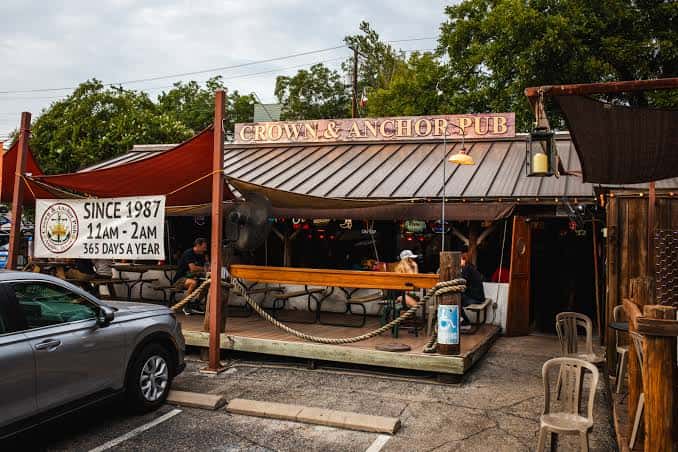 Fachada del pub con letrero de 'Since 1987' y zona de asientos en la calle