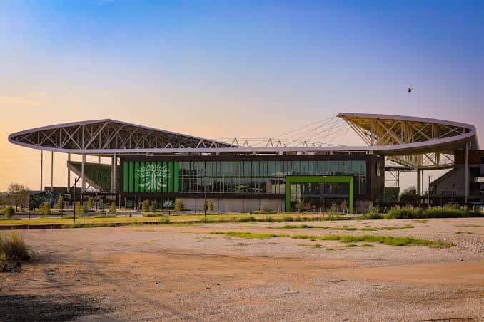 Vista exterior del Q2 Stadium en Austin al atardecer con su distintiva estructura de techo y fachada verde