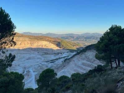 Vista panorámica de la antigua cantera del Cerro Carramolo con estratos blancos y vegetación mediterránea